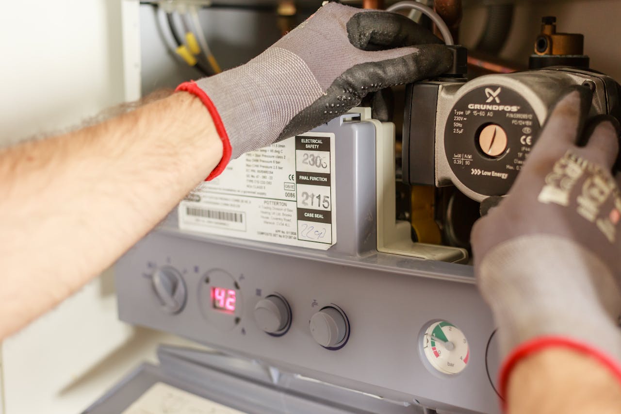 journey Close-up of hands adjusting a boiler system with precise instrumentation, showing maintenance work.